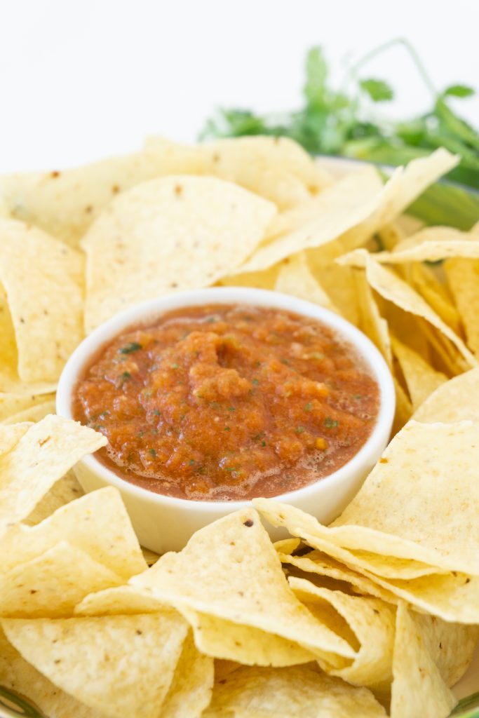 serving tray with white corn tortilla chips and dish of blender salsa