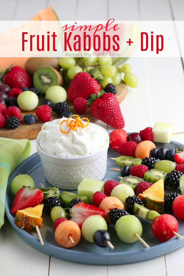 Fruit Kabobs and fruit dip on blue plate for serving with fruit in the background