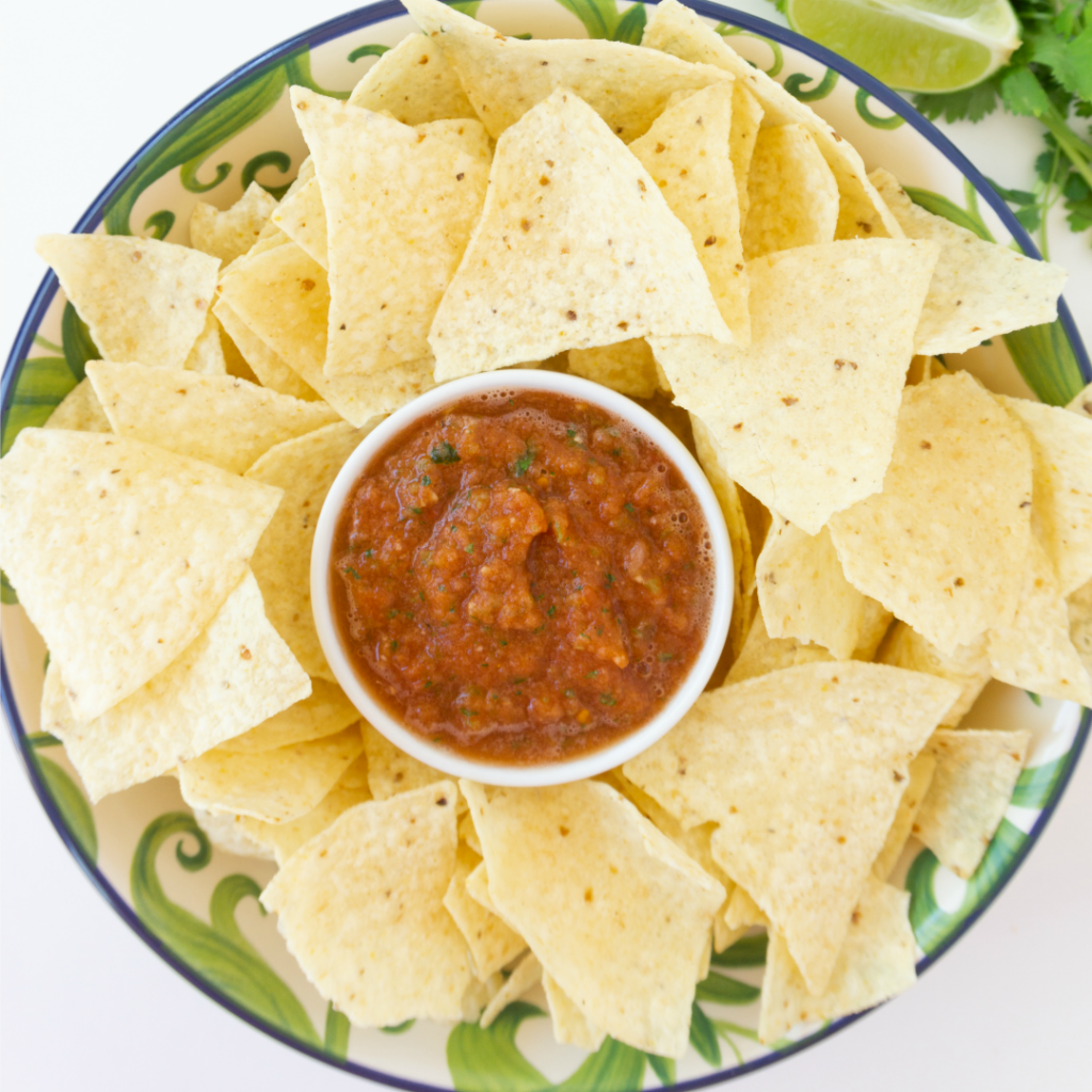 serving dish of easy homemade salsa surrounded by tortilla chips for dipping