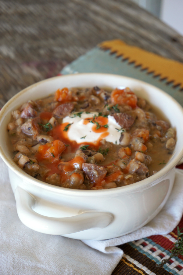 white soup crock with Black Eyed Pea Soup, made in a slow cooker