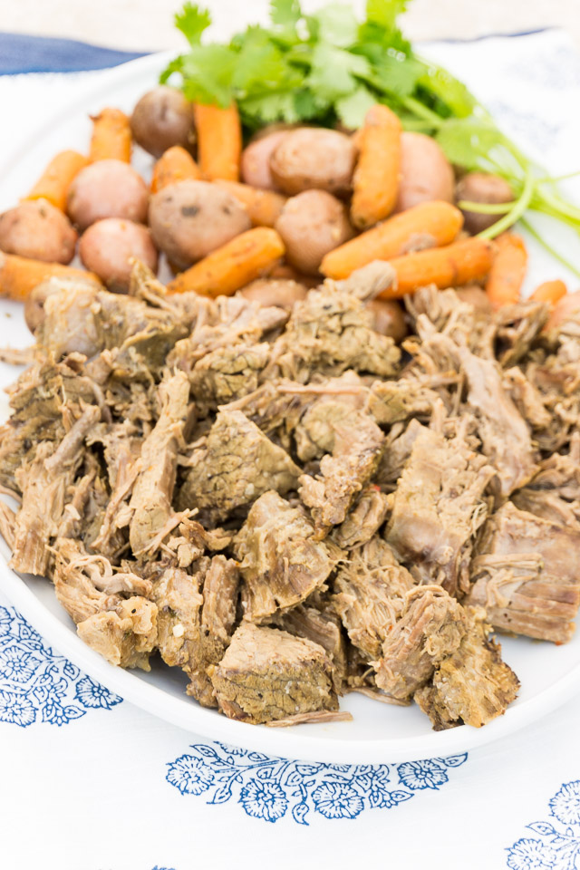 shredded pot roast on white platter with carrots and potatoes | 3 Packet Pot Roast Recipe