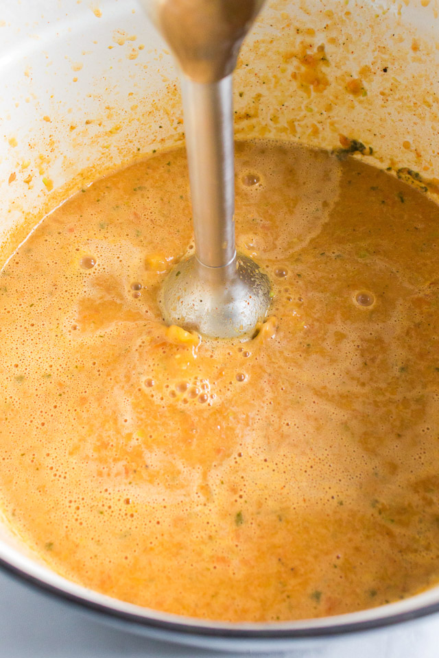 using an electric stick blender to puree gluten free taco soup in a large pot