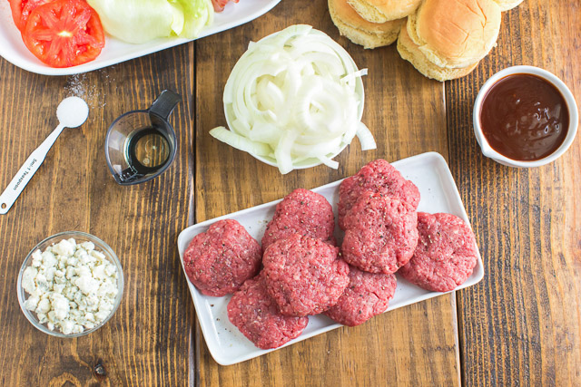 overhead photo: tray of raw ground beef patties and other beef slider recipe ingredients on counter