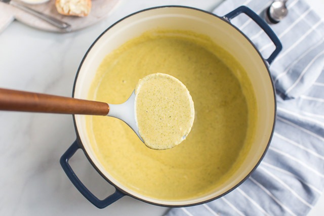overhead image: homemade cheese soup in large pot with ladle of soup above it