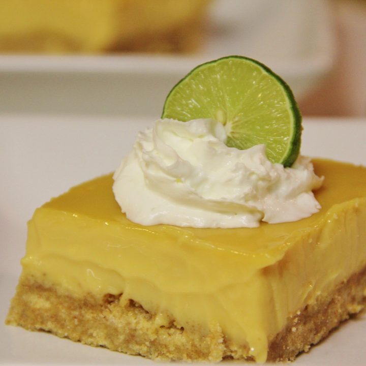 serving of key lime pie topped with whipped cream and lime slice