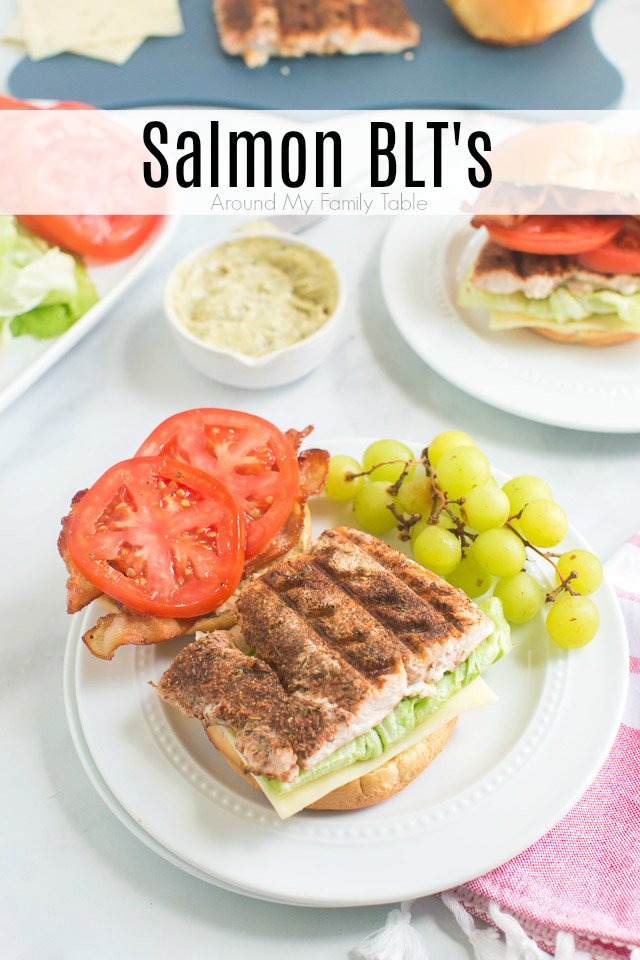 grilled blackened salmon BLT sandwich and green grapes on white plate