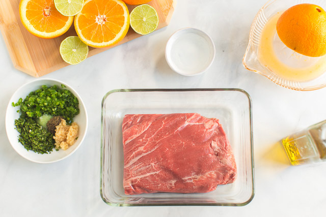 raw flank steak oranges, limes, and seasoning for steak taco recipe