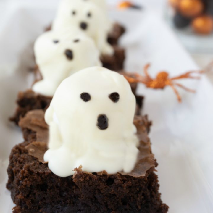 Brownies with ghost marshmallows on white platter