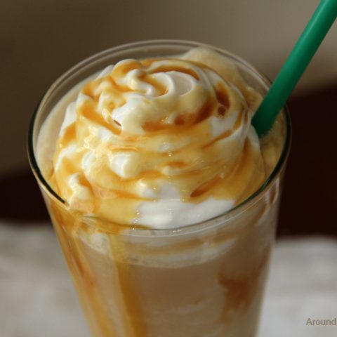 caramel macchiato in a tall glass with whipped cream and caramel sauce