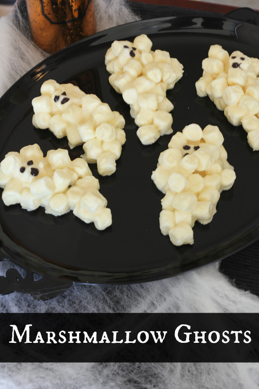 Super fun and spooky Halloween treat that the kids can help make.  These Marshmallow Ghosts are frighteningly simple to make.