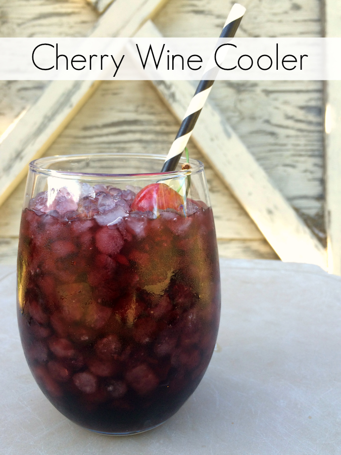 cherry wine cooler in a tall glass with a straw