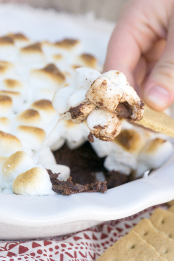 Ooey gooey S'mores Dip will be your new family favorite!  A blend of chocolate and heavy cream that's topped with roasted marshmallows makes a scrumptious dessert! #smores #desserts #smoresdip #chocolatedessert