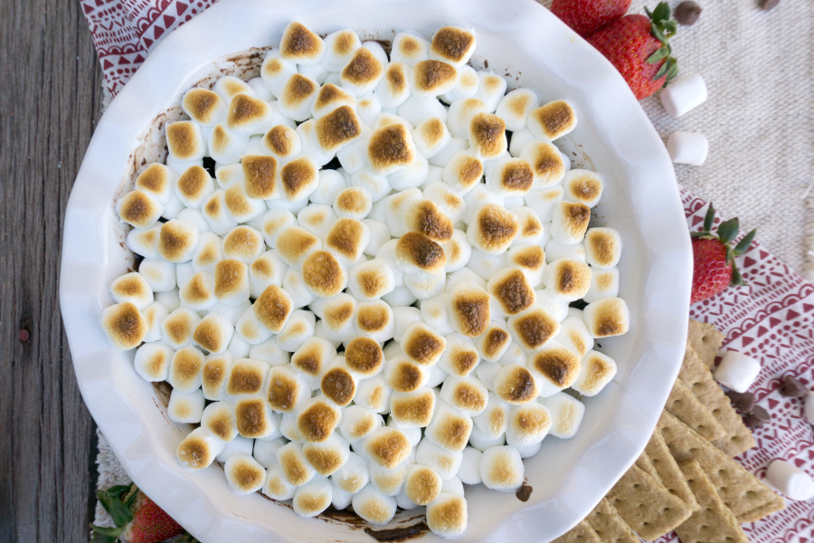 Ooey gooey S'mores Dip will be your new family favorite!  A blend of chocolate and heavy cream that's topped with roasted marshmallows makes a scrumptious dessert! #smores #desserts #smoresdip #chocolatedessert