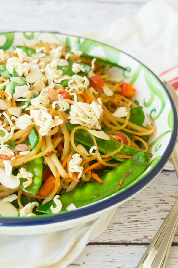 Change up your traditional summer pasta salad for this Spicy Asian Pasta Salad, it will be the hit of all your summer parties! This pasta salad is full of fresh vegetables and topped with some crushed ramen noodles and slivered almonds. #pastasalad