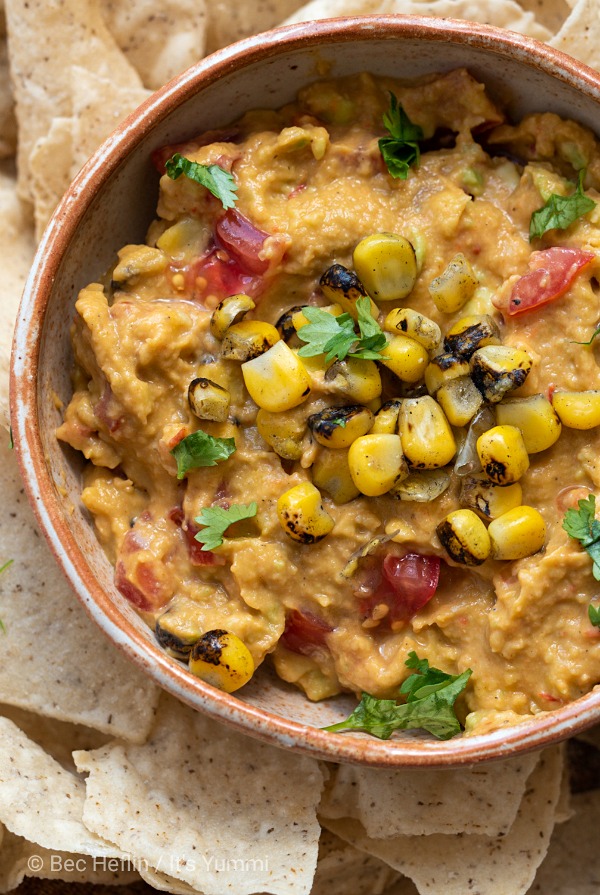 spicy avocado hummus topped with tomatoes, corn and black beans