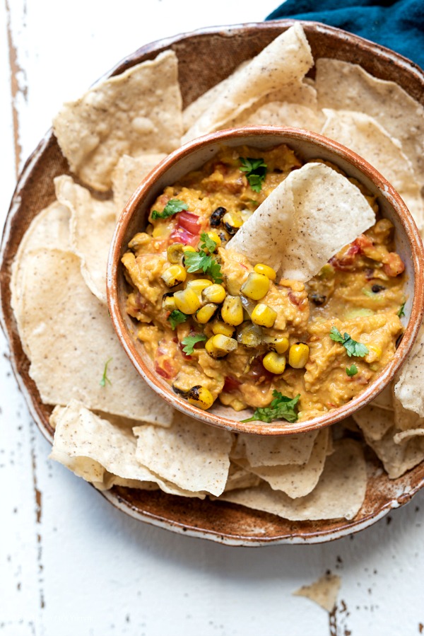 bowl of homemade avocado hummus with black beans and corn