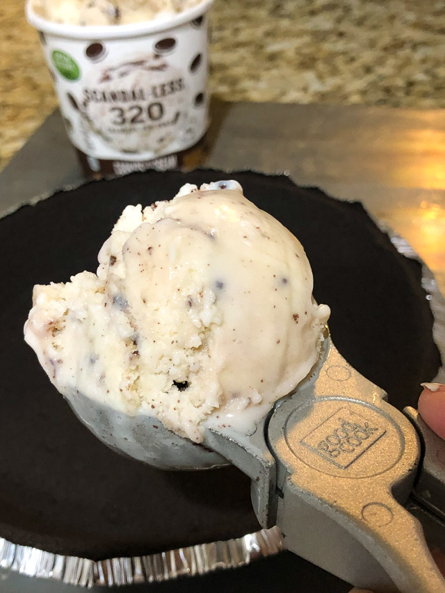 Scoop of ice cream being put into a cookie pie crust