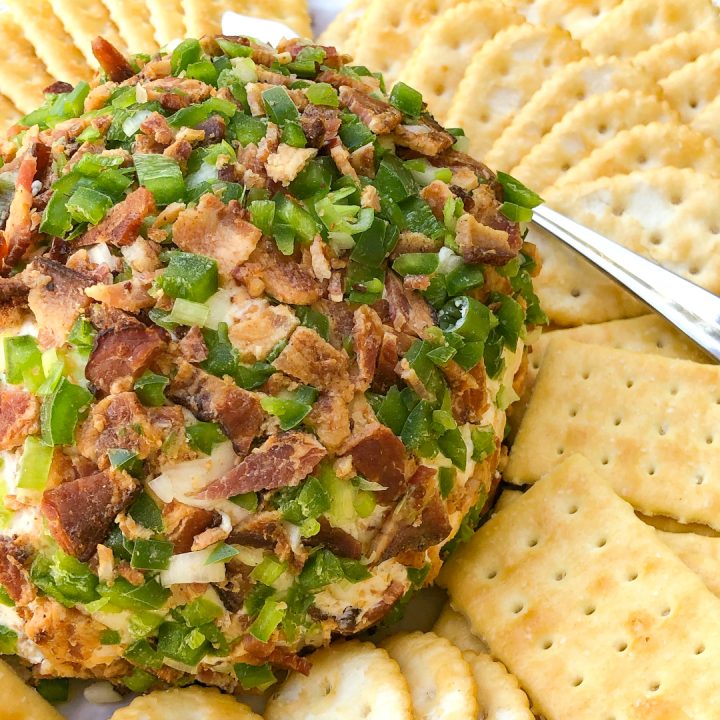 Jalapeño Bacon Cheese Ball on a white platter with crackers
