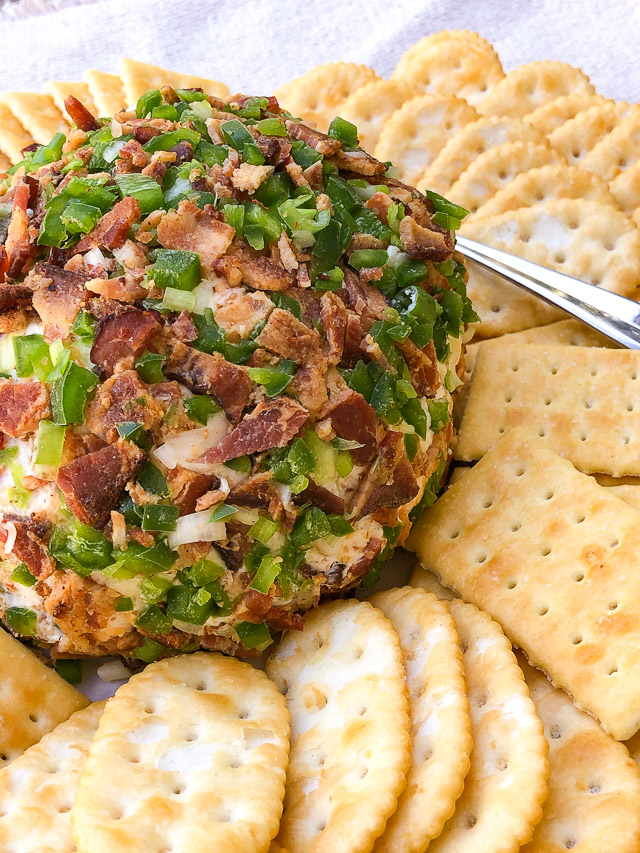 Jalapeño Bacon Cheese Ball on a white platter with crackers