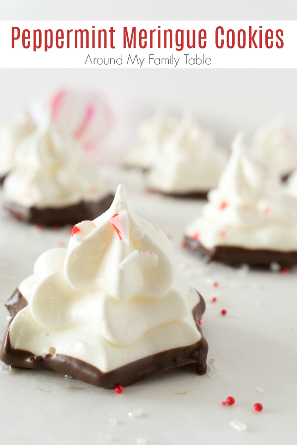 Peppermint meringues are crisp meringue cookies dipped in chocolate, with a festive topping of peppermint candies. Perfect Christmas cookies recipe! #meringue #christmascookies #peppermintcookies via @slingmama