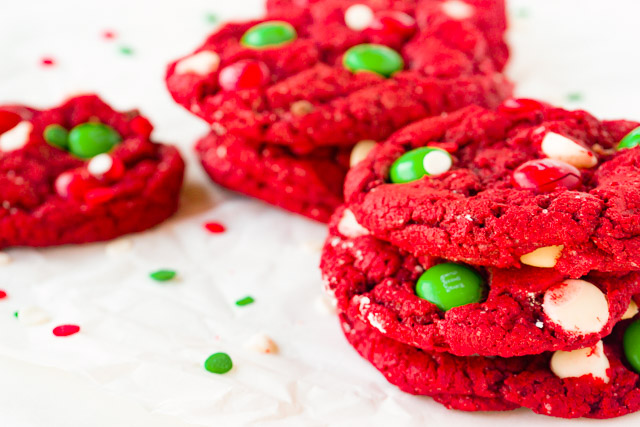 short stack of red velvet cookies with green M&Ms and white chocolate chips