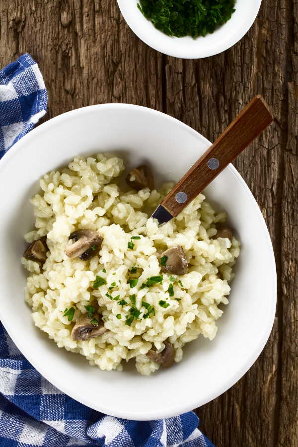risotto in white bowl on wood table