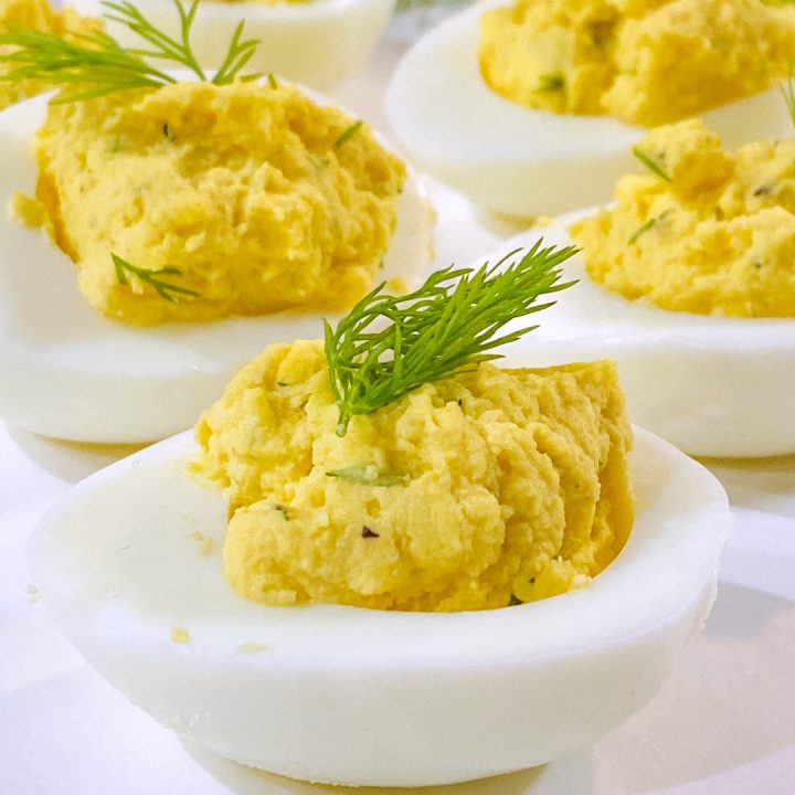 dilled deviled eggs on white plate