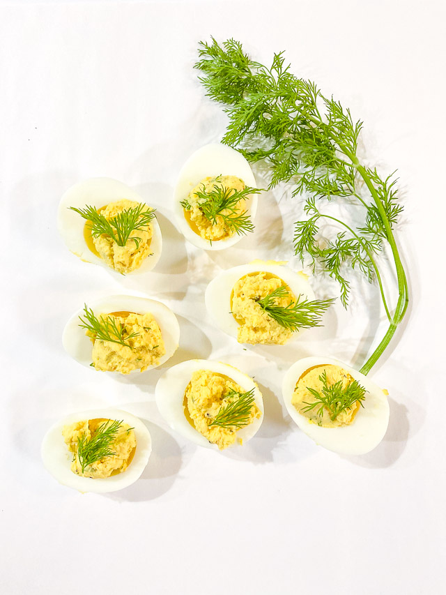 dilled deviled eggs on white plate