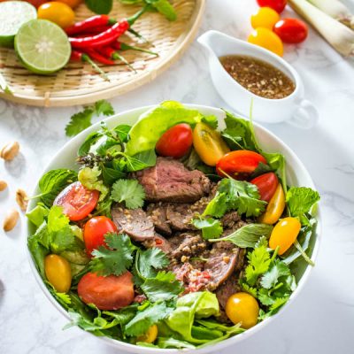 thai beef salad in a white bowl