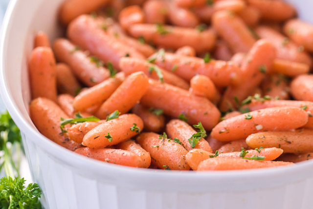 roasted baby carrots in a white pan