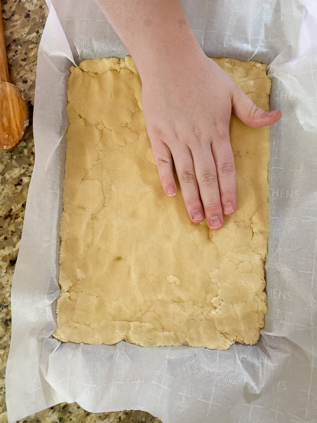 pressing the Snickerdoodle Cookie Bars ingredients in a pan