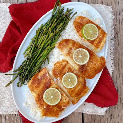 Cajun Oven Baked Cod on a plate with rice and asparagus