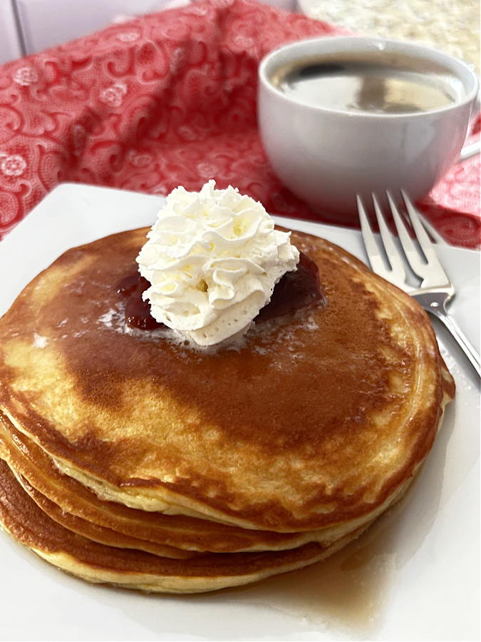 keto pancakes on white plate with a cup of coffee