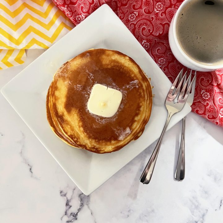 keto pancakes on white plate with a cup of coffee