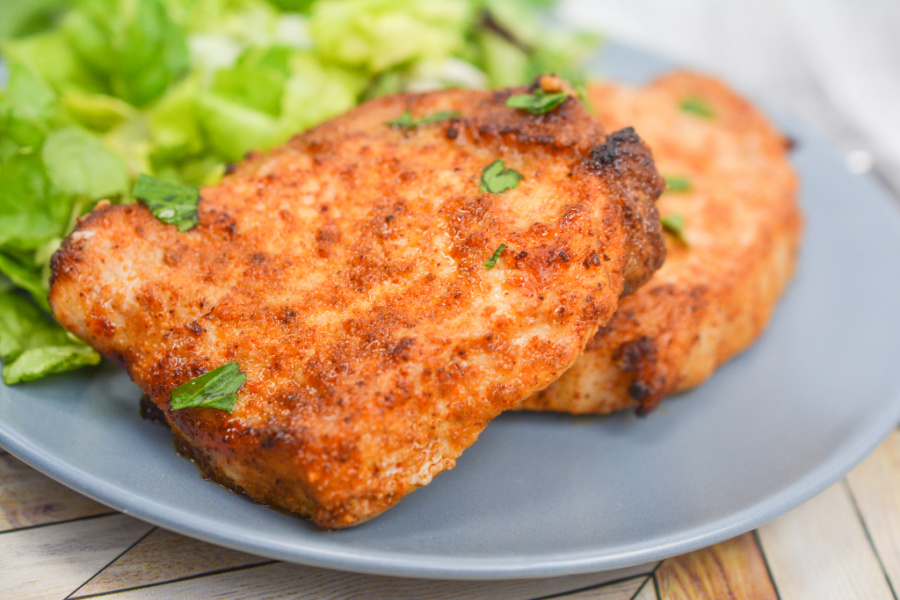 keto air fryer pork chops and salad on a blue plate