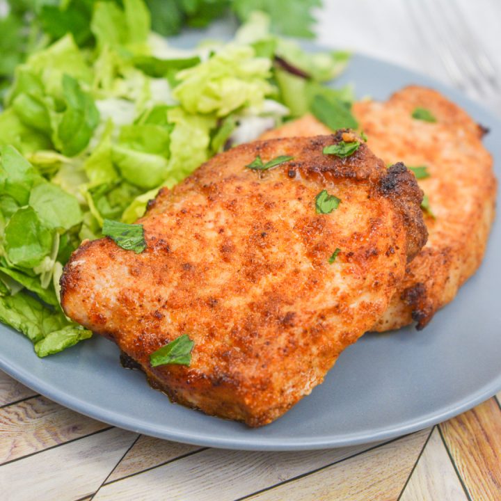 keto air fryer pork chops and salad on a blue plate